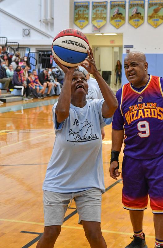 Former Principal Janet Maull-Martin puts in a shot with Arnold "A-Train" Bernard playing loose defense.