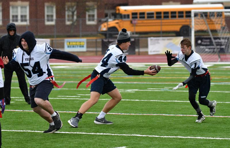Cape quarterback Josh Reinhold hands off to Tony Palmer while center Hudson Keller blocks downfield.