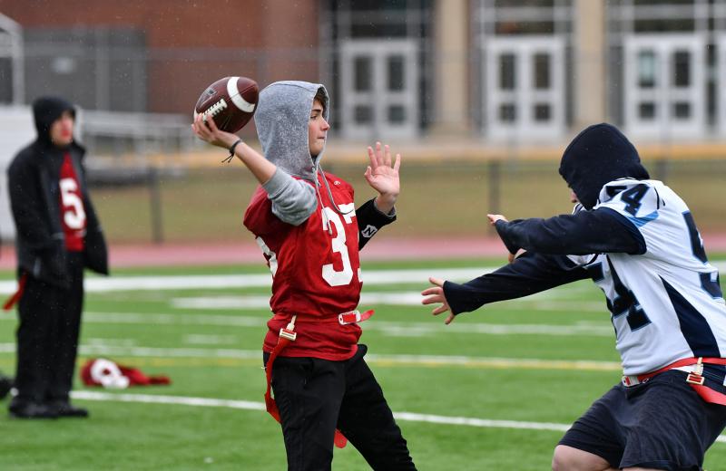 Smyrna quarterback Kylie Thomas tries to get the pass downfield while being rushed by defensive lineman Hudson Keller.