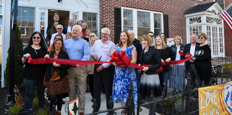A large crowd takes part in the Nov. 11 ribbon cutting at the new Active Adults Realty office at 104 Second St., Lewes. In front holding the ribbon are (l-r) Micha Seto, owner of Blooming Boutique in downtown Lewes; Nikki Fisher, Lewes Chamber of Commerce board president; Lewes Mayor Ted Becker; Bill Davis, owner/broker; Christine Davis, owner/associate broker; and Betsy Reamer, Lewes Chamber of Commerce executive director. They are joined by staff, Realtors, friends and affiliates. RON MACARTHUR PHOTOS