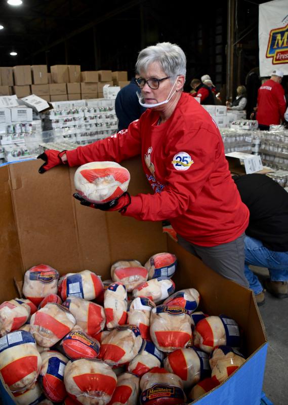 Chuckie Emerson of Bridgeville is at the end of the line handing Mountaire roaster chickens to other volunteers.