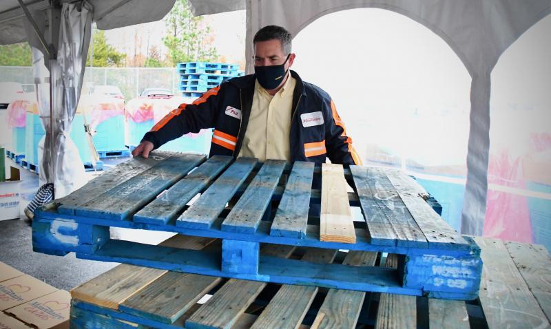 Mountaire Farms President Phil Plylar helps out as well, setting up a pallet to stack packed food boxes on.