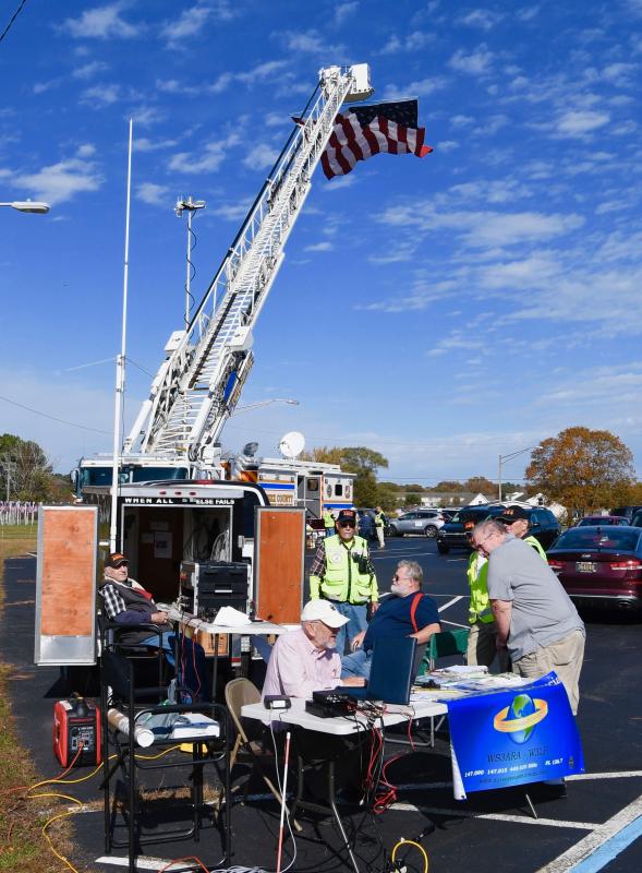 With the Indian River Volunteer Fire Co. aerial truck in the background, members of the Sussex Amateur Radio Association provide a live demonstration of how they operate.