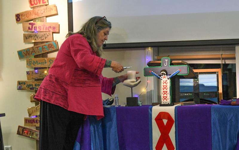 The Rev. Diane Fisher of Metropolitan Community Church lights a candle for people who have passed away from AIDS.
