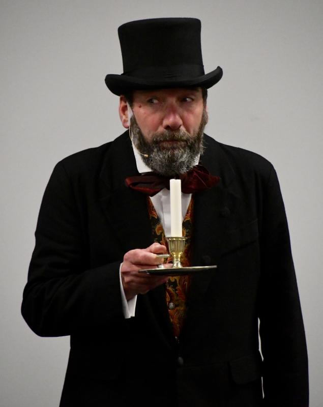 As Scrooge, the actor uses caution as he enters his dark apartment. Gerald Dickens plays nearly 30 parts in his one-man show.