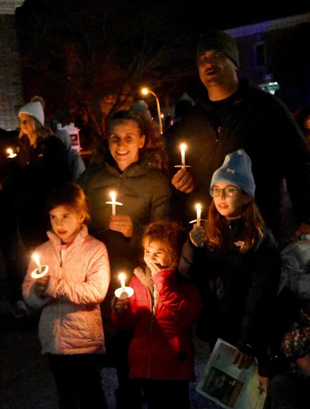 The Rainey family sings “Silent Night” while holding candles as the traditional end to Caroling on The Circle.