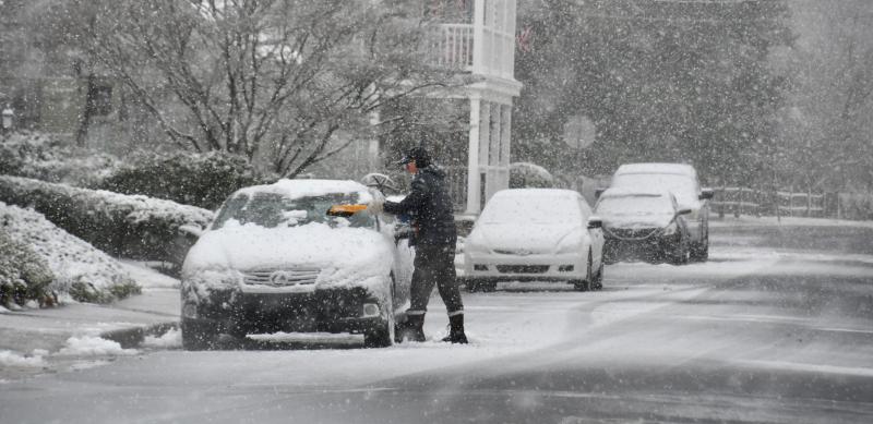 Not many people in the Cape Region are venturing out during the storm. This downtown Lewes resident is making an effort to keep his car free of snow. RON MACARTHUR PHOTO