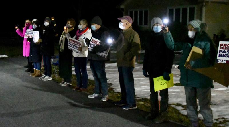 With lights and signs in hand, vigil attendees stand in silence Jan. 6 in front of the Unitarian Universalists of Southern Delaware church near Lewes in remembrance of the events that transpired in Washington, D.C., one year ago. RON MACARTHUR PHOTOS