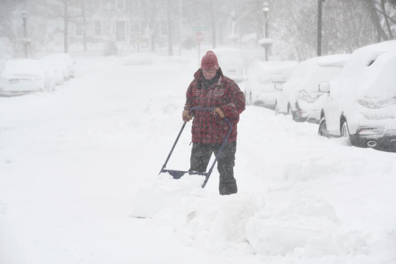 Rick Grier-Reynolds, wearing his Pennsylvania tuxedo, helps neighbors by shoveling snow on Second Street in Lewes. RON MACARTHUR PHOTO