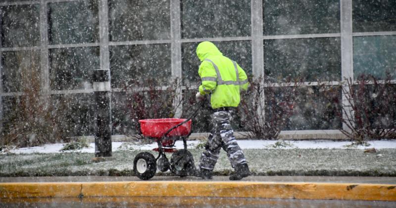 A Beebe Healthcare worker spreads ice melt on the sidewalks around the facility on Savannah Road in Lewes. RON MACARTHUR PHOTO