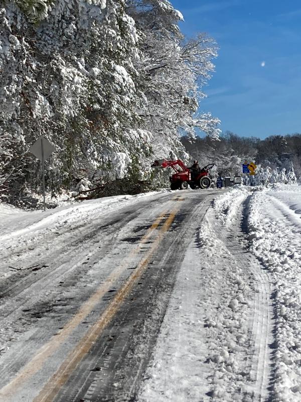 The cleanup after a snowstorm is often a case of neighbors helping neighbors. In this case, Paul Downey lends a helping hand to clear a fallen tree in the road.