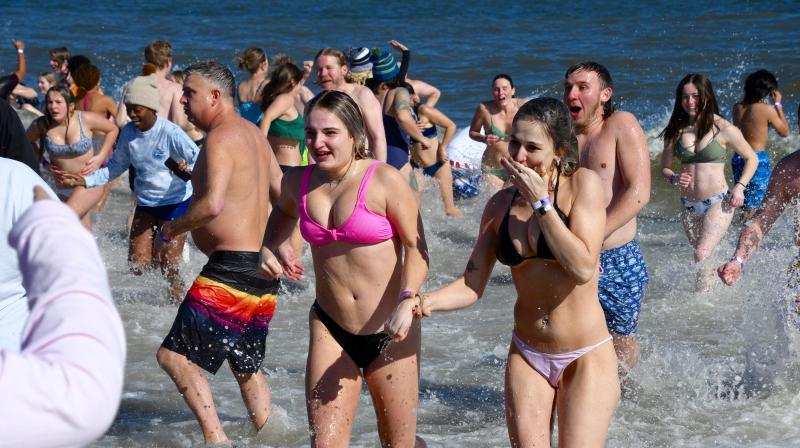It’s a mass of humanity as Lewes Polar Bear Plunge participants run into and out of the cold ocean water. RON MACARTHUR PHOTO