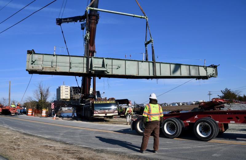 The swing bridge is turned around by the Digging & Rigging crane operator to be lowered onto a trailer along Gills Neck Road.