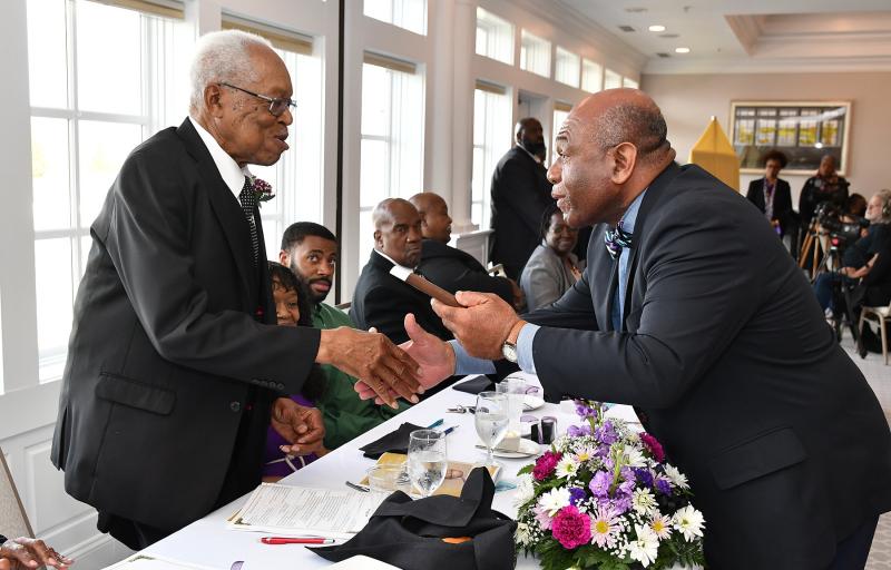 The Rev. George Edwards receives a plaque of recognition from Bill Collick of the Community Celebration Committee.