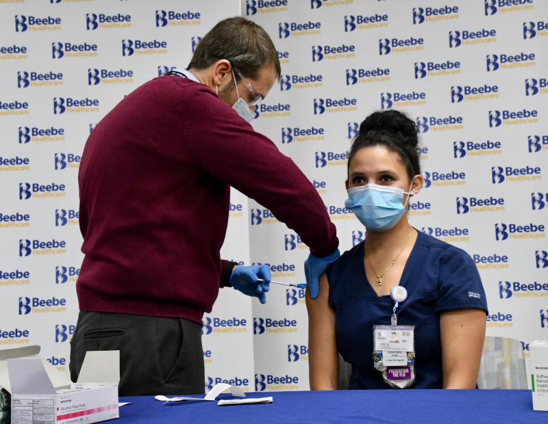 Wearing masks is still required in Delaware hospitals and many other healthcare settings, even as some COVID-19 restrictions are changing.
This photo from Dec. 16, 2020, shows Beebe Healthcare nurse Sintia Rodriguez, the first person in Sussex County to get a COVID-19 vaccine shot, and Dr. William Chasanov. RON MACARTHUR PHOTO