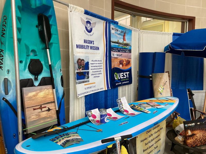 The booth for Quest Adventures featured a stand-up paddleboard, beach chairs and a kayak.