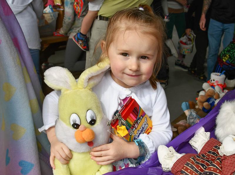 Airanna Flickinger, 2, hugs her bunny and toys donated by American Legion Auxiliary Unit 28 at the animal blessing and Easter egg hunt.
