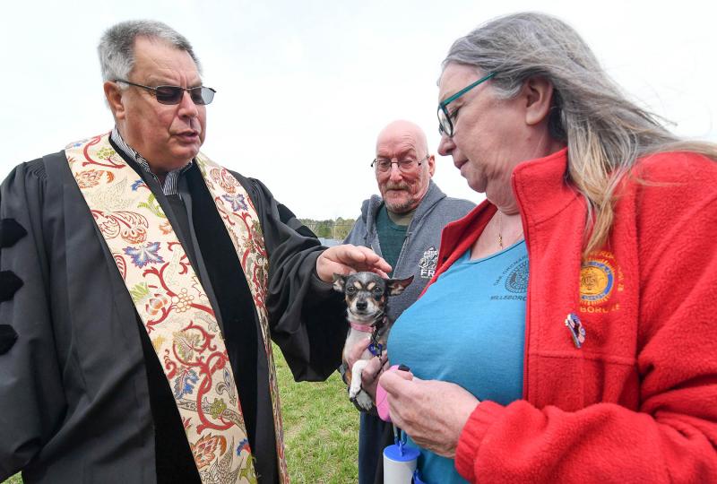 Pastor Emeritus Jim Vanderwall blesses Zoey, a 6-year-old Chihuahua owned by Linda Harcum and Joey Long of Georgetown.