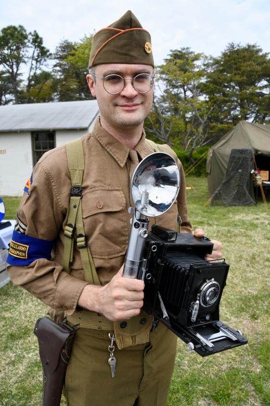 A photo of a photographer. Re-enactor Jeffrey Batt has an authentic Graflex camera, the official camera of the U.S. armed forces during World War II.
