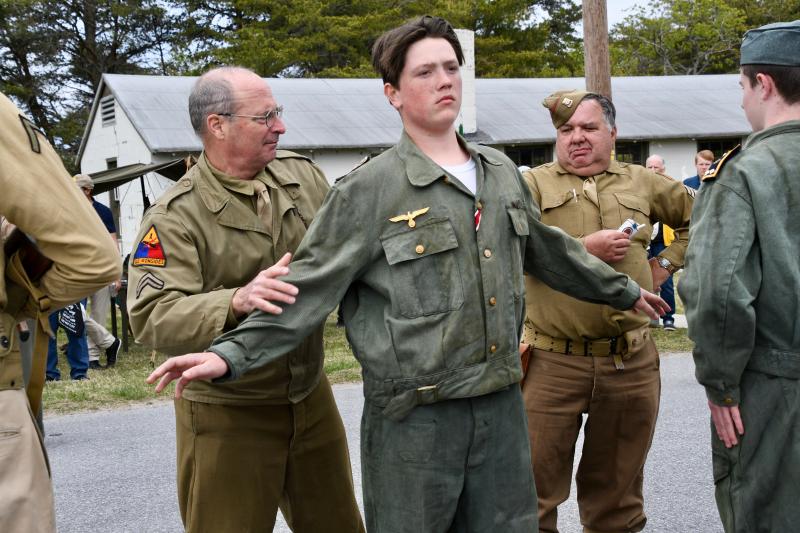 Re-enactor Cpl. John Henderson pats down a member of the German submarine crew prior to transporting the prisoners.