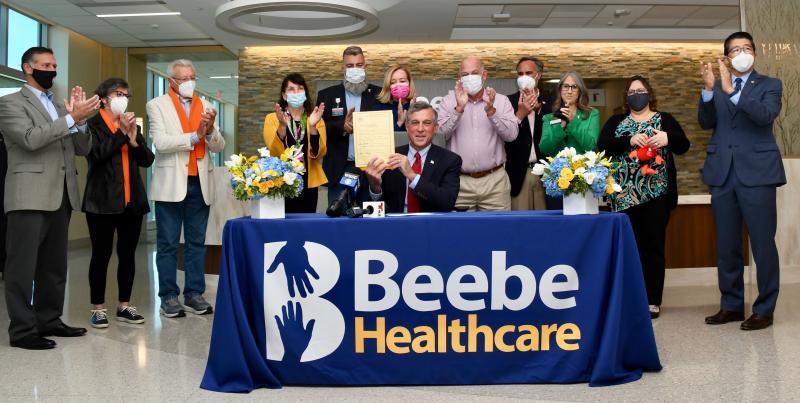 Gov. John Carney is joined at the signing into law of SB 218 by (l-r) Rep. Steve Smyk, Patricia and Charles Harvey, State Auditor Kathy McGuiness, Beebe Healthcare Board of Directors Chair Christian Hudson, organ transplant recipient Missy Jones, Speaker of the House Rep. Pete Schwartzkopf, Sen. Ernie Lopez, National Kidney Foundation officers Nicole Scharf and Kristy-An Ferracci, and Beebe Healthcare President and CEO David Tam. RON MACARTHUR PHOTOS