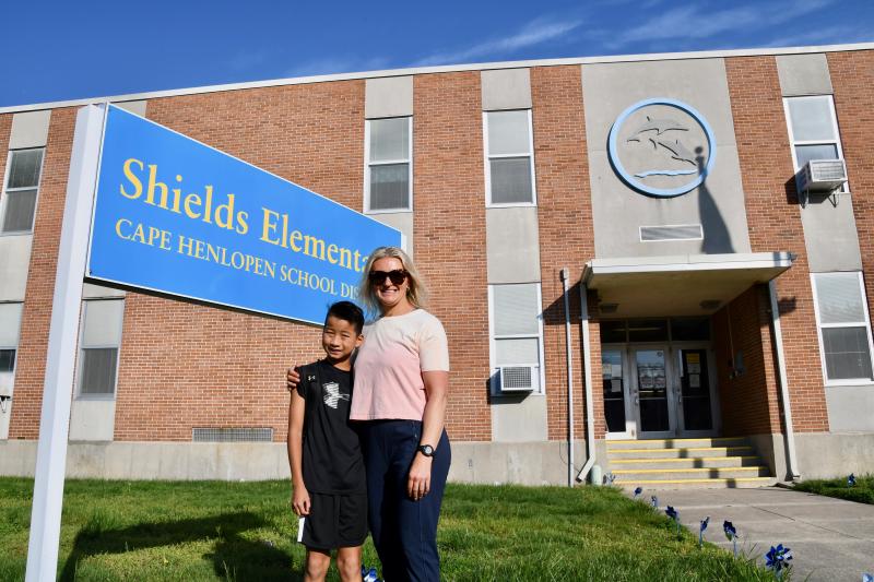 Shields PTO President Jennifer Kaufmann and son Julian pose for a photo in front of the school sign on the last day.