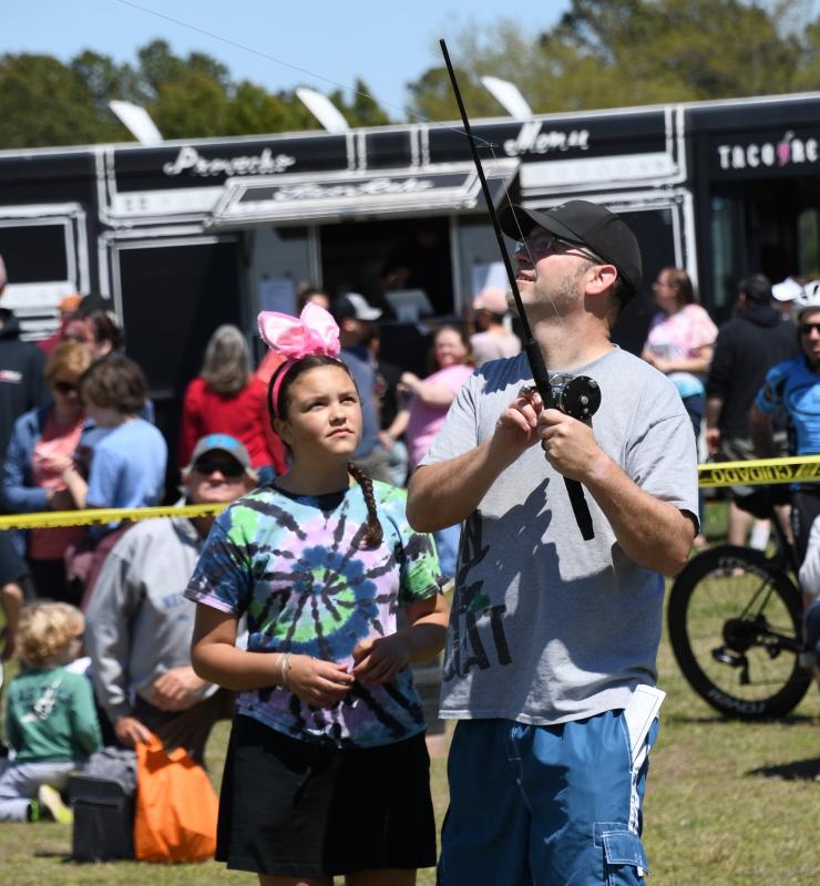 Drew Cline and his daughter Charlotte use a fishing pole to fly their kite in the highest-flyer contest.