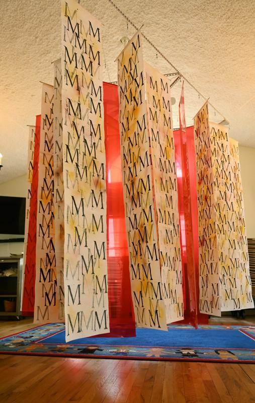 Mark Harris stamped the letter M 1,000 times – 50 times on each of 20 pieces of rice paper – to signify 1 million lives lost. M is the Roman numeral for 1,000.