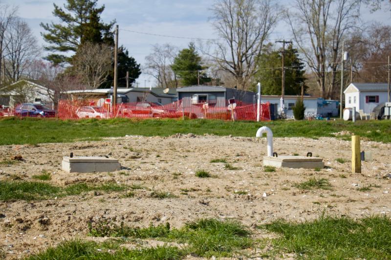 A large septic field with one area closed off and another area covered in fill dirt from recent work.