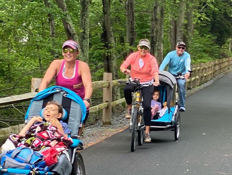 With her parents Sherry and Dan Stephens riding behind her, Sara Carter runs along the Lewes-to-Georgetown Trail.