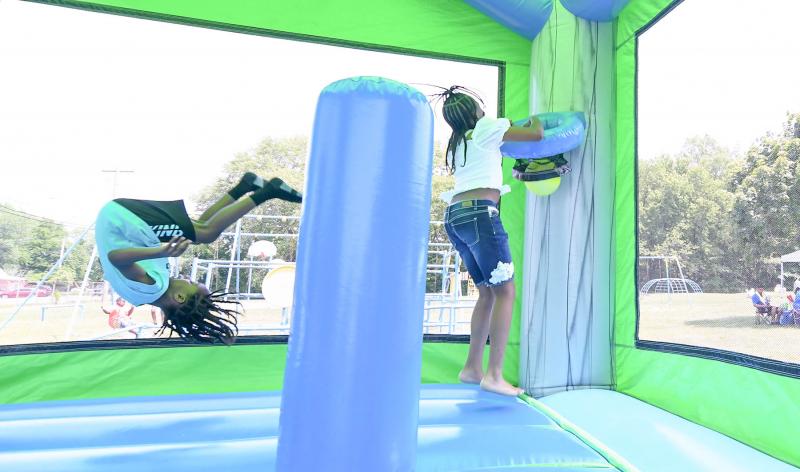 Karter Jones Akins, 6, flips while Jada Robins dunks in the bounce house.