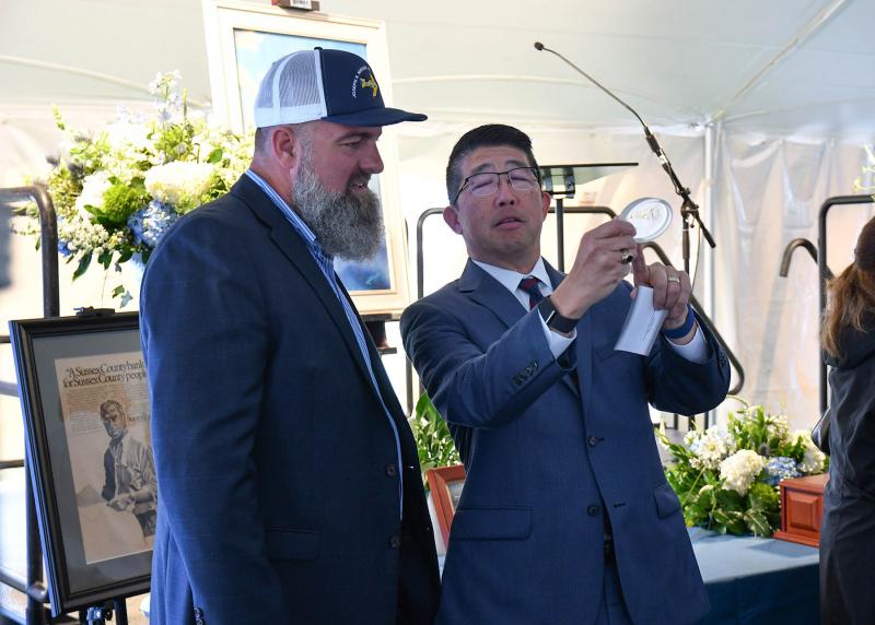 Beebe Healthcare President and CEO Dr. David Tam, right, gives Christian Hudson a paperweight commemorating the Joseph R. Hudson Emergency Wing.