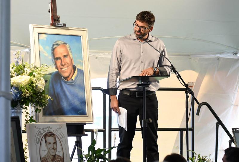 Abraxas Hudson stands next to a portrait of his grandfather he painted. He spoke about his grandfather’s legacy.