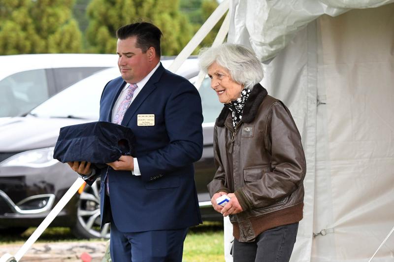 Andrew Parsell carries Joe Hudson’s urn as daughter Susie walks to the Stearman biplane in which she would fly around the Hudson property. Susie is wearing her father’s bomber jacket for the flight.