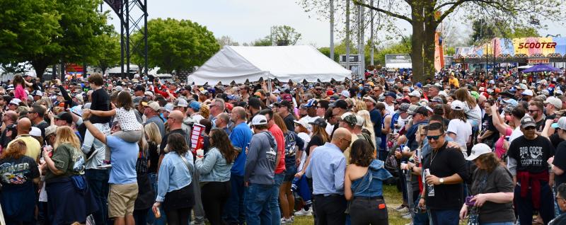 A large crowd fills the green space outside the Dover Motor Speedway to listen to country star Jimmie Allen.