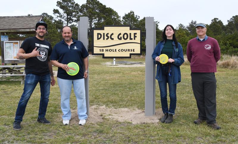 Meeting to unveil the Cape park disc golf improvements, including a new sign, are (l-r) Albert Lambert and Miguel Garces, volunteers; Gloria Mitchell, assistant park superintendent; and Bob Bracco, president of Friends of Cape Henlopen State Park.