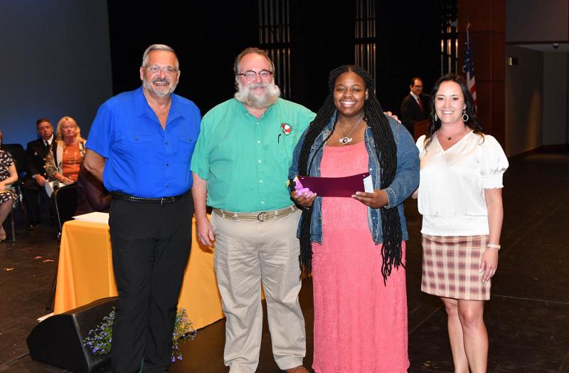 Erycca Curry received the F.H & L.O. Russell Scholarship and the Rehoboth Beach Bears Gay-Straight Alliance Scholarship. Shown are (l-r) Rocky Bible, Kenny MaHan, Curry and Cape Principal Nikki Miller.