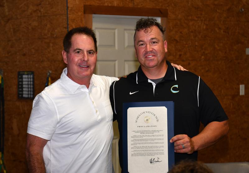 Sussex County Councilman Mark Schaeffer presents a proclamation honoring the state championship to Cape head coach Ben Evick.