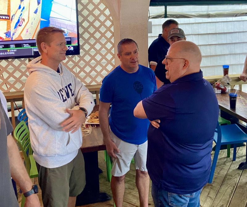 Dewey Beach Town Manager Bill Zolper, left, and Mayor Bill Stevens greet Maryland Gov. Larry Hogan on the restaurant deck.