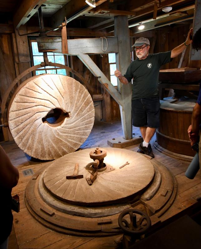 Steve Childers, the man behind the machines at Abbott’s Mill, explains how a millstone works. RON MACARTHUR PHOTO