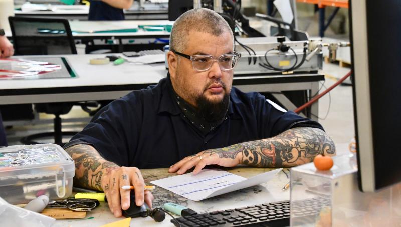 Bob Brown enters data to track materials used in sign fabrication. Computers are now key to sign making.
