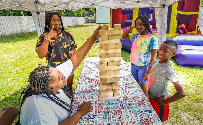 Playing a competitive game of Jenga are (l-r) Tyasia Mann, 16; Harmony White, 11; Zynnasia White, 12; and Aiden White, 8.