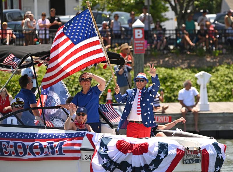 The Freedom Boat Club leads the parade past Fisherman’s Wharf. Membership Director Rob Sweeney holds the flag, while owner Bev Rosella scans the crowds ashore.