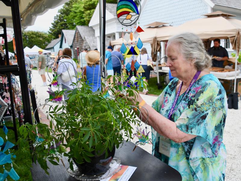 Kit Hanson of Sandy Hook Art Glass Studio in Ocean Pines, Md., adds the finishing touches to a plant decorated with some of her glass creations.
