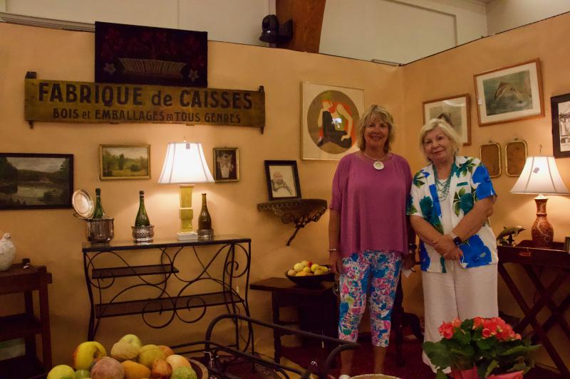 Barbara Rew stands with her sister Kathy Carpenter in front of her set-up that was reminiscent of an entertaining room.