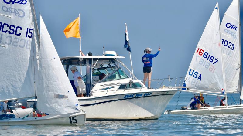 LYC principal race officer Michelle Bland is surrounded by Club 420 sailors as she takes a wind reading.