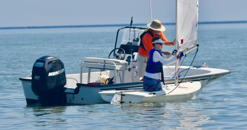LYC Sailing Director Angus Robertson helps Grant Cummins rig his mast before starting a race in the Laser Radial fleet.