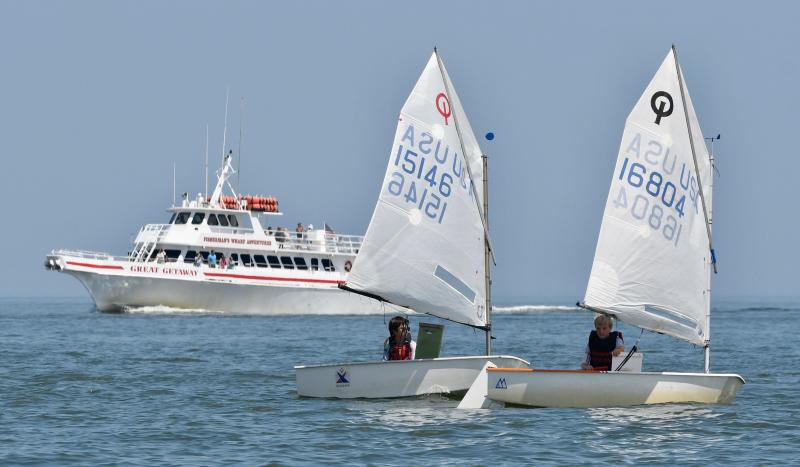 With one of Parsons’ Fisherman’s Wharf boats in the background, Annapolis Yacht Club sailors Trey Waters (15146) and Jamison Jones (16804) compete in the Optimist green fleet.