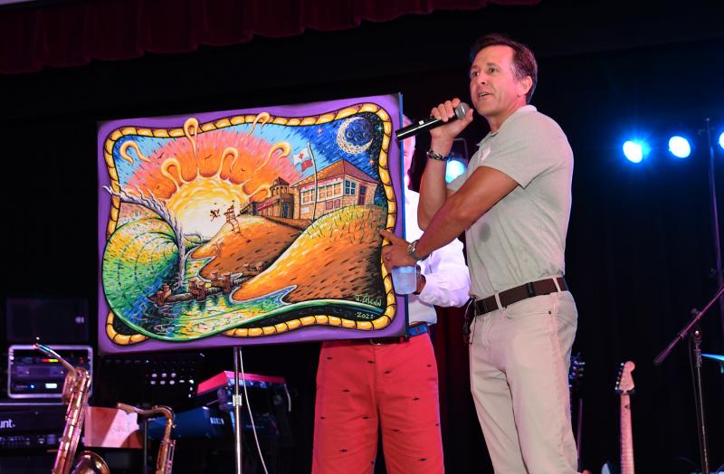 Former guard Tim Green (1993-2003) displays a painting donated for silent auction by New Jersey guard John Glenn.