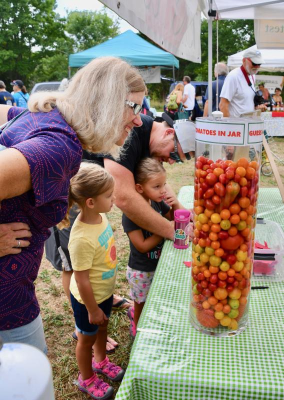 Members of the Hiester family of Cherry Hill, N.J., and the Coburn family of Lewes try to figure out how many tomatoes are in the jar.